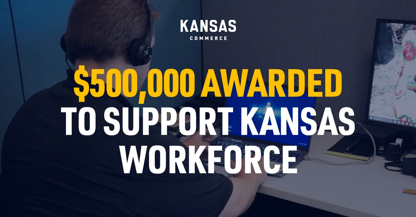 A person wearing headphones is seated at a desk, working on a laptop. The screen shows a virtual meeting interface. Nearby, a large text on the image reads: "$500,000 awarded to support Kansas workforce." The logo of Kansas Commerce is displayed at the top.