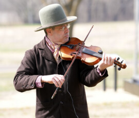 A violinist plays in the field.