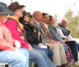Audience members listen to speaker under a tent at the Pony Express dedication event.