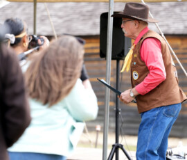 A rider carries a proclamation document up to the stage.
