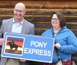 Sec. Reed holds the new Pony Express designation sign.